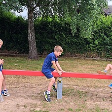 Foto einiger Kinder auf einer Wippe