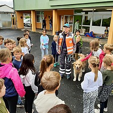 Gruppenfoto der Kinder mit einer Hundefüherrin