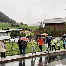 Teilnehmer der Seniorenfahrt bei Regen auf dem Bürgersteig