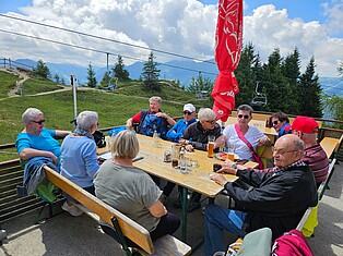 Gruppenbild: Teilnehmerinnen sitzen auf der Alm am Jakobskreuz