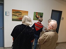 Foto einiger Besucher beim betrachten der Bilder der Künstlerin