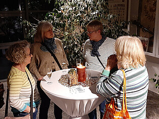 Menschen stehen im Flurbereich beim Sektempfang