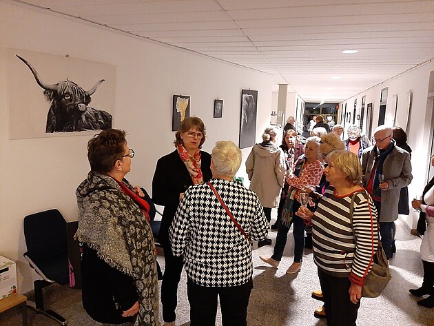Besucher unterhalten sich mit der Künstlerin Angelika Eberlein-Fleck