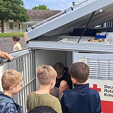 Foto der Kinder, bei der Beschtigung des Hundeanhängers