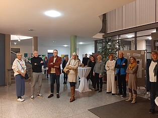 Während der Eröffnungsrede, Menschen im Foyer