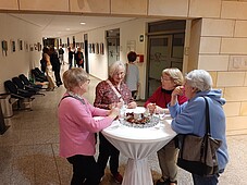 Foto einiger Besucher stehend an einemm Stehtisch