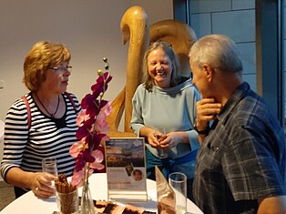 Foto einiger Besucher an einem Stehtisch vor dem Trausaal
