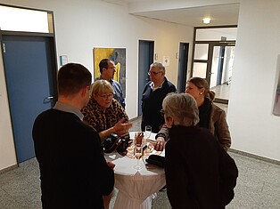 Austausch am Stehtisch nach Eröffnung von Besuchern und Besucherinnen
