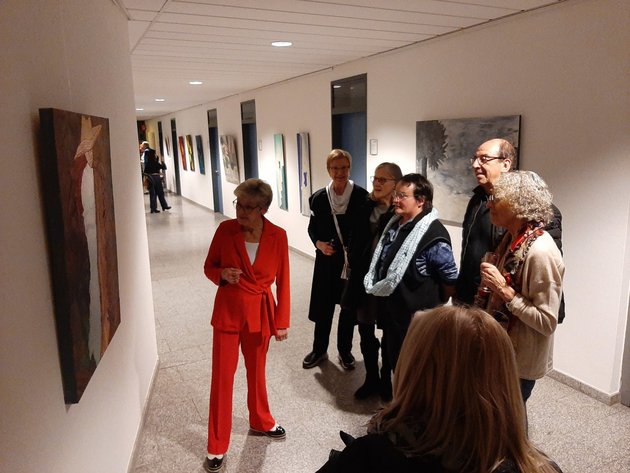 Frau Imke (links im Bild) erläutert Besuchern und Besucherinnen der Ausstellung einige Exponate