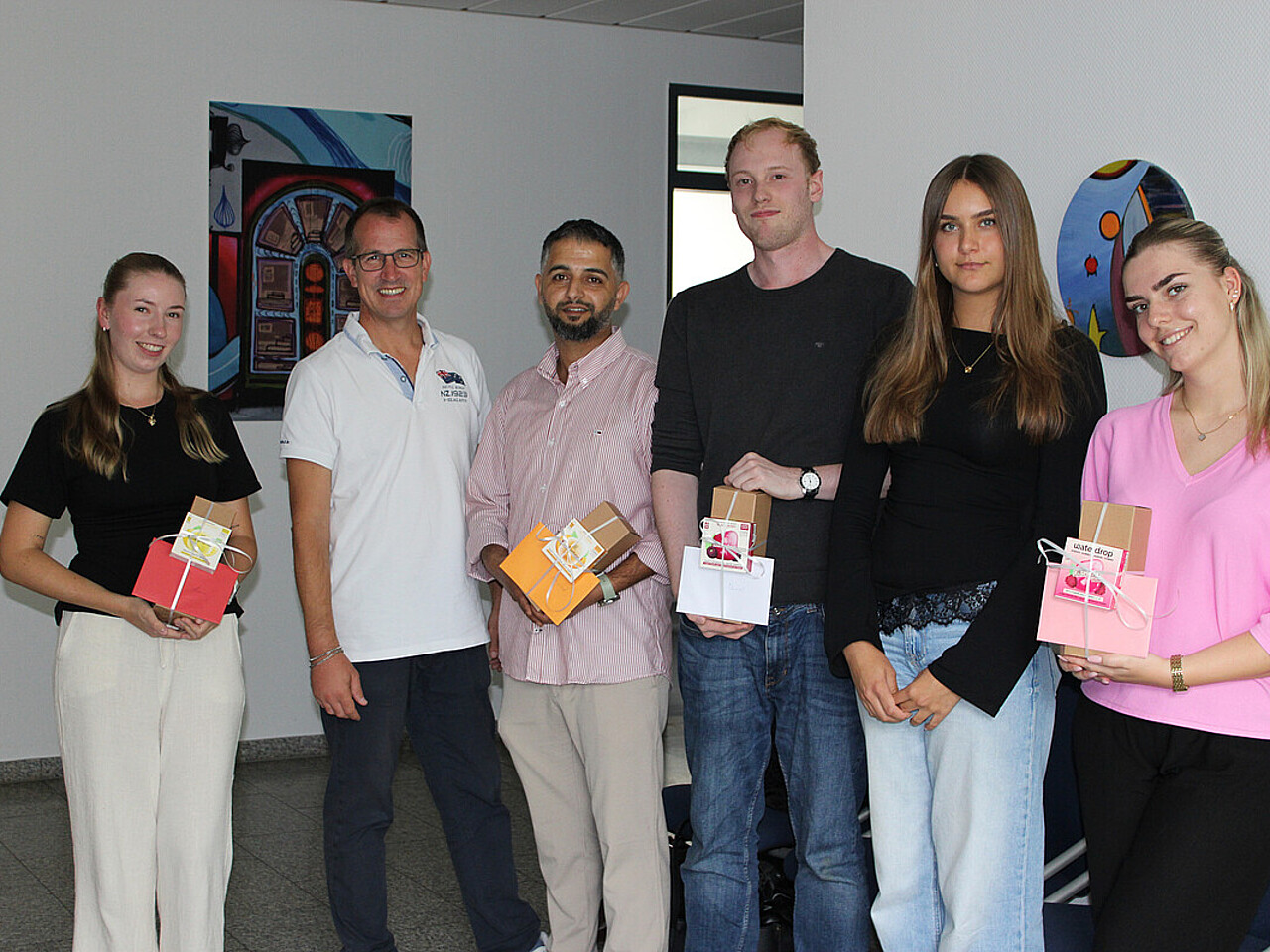 v.l. Anna Minich, Andeas Damm (Bürgermeister), Khaled Alrashid, Daniel Ruppel, Lilli Winterhoff, Mila Liehmann stehen im Rathaus mit einem Willkommensgeschenk in der Hand