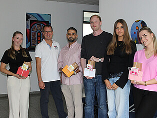 v.l. Anna Minich, Andeas Damm (Bürgermeister), Khaled Alrashid, Daniel Ruppel, Lilli Winterhoff, Mila Liehmann stehen im Rathaus mit einem Willkommensgeschenk in der Hand