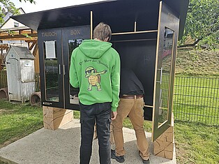 Zwei Schüler bei den letzten Handgriffen zum Aufbau der Tauschbox
