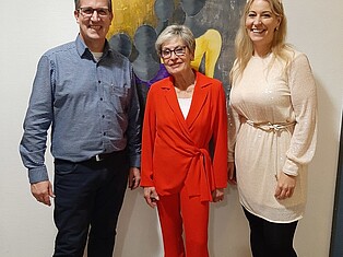 BGM Damm, Künstlerin Imke, Kulturbeauftragte Baumann vor Werbe-Gemälde der Ausstellung