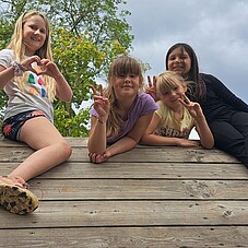 Foto einiger Kinder auf dem Dach eines Klettergerüst auf einem Spielplatz