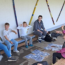Foto der Kinder mit einer Hundefürherin und ihrem Hund. Spielen ein Rate-Spiel