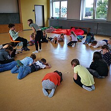 Foto einiger Kinder in einem Klassenraum bei einem Spiel