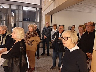 Während der Eröffnungsrede, Menschen im Foyer