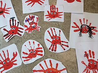 Mit Fingerfarbe und Handabdücken erstellte Krebse auf Papier, die anschließend noch mit Stiften erweitert wurden