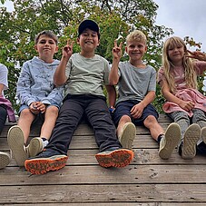 Foto einiger KInder auf dem Dach eines Klettergerüst auf einem Spielplatz