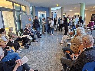 BesucherInnen stehen und sitzen während des Flötenquartetts in der 1. Etage