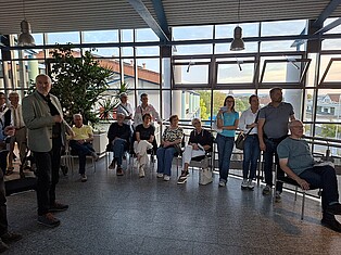 BesucherInnen stehen und sitzen während des Saxophonensembles in der 2. Etage