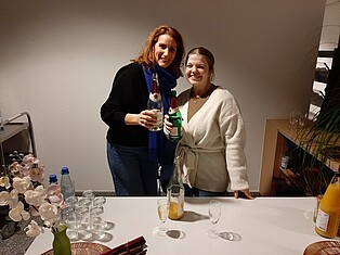 Foto von zwei Damen, die jeweils eine Flasche Sekt halten