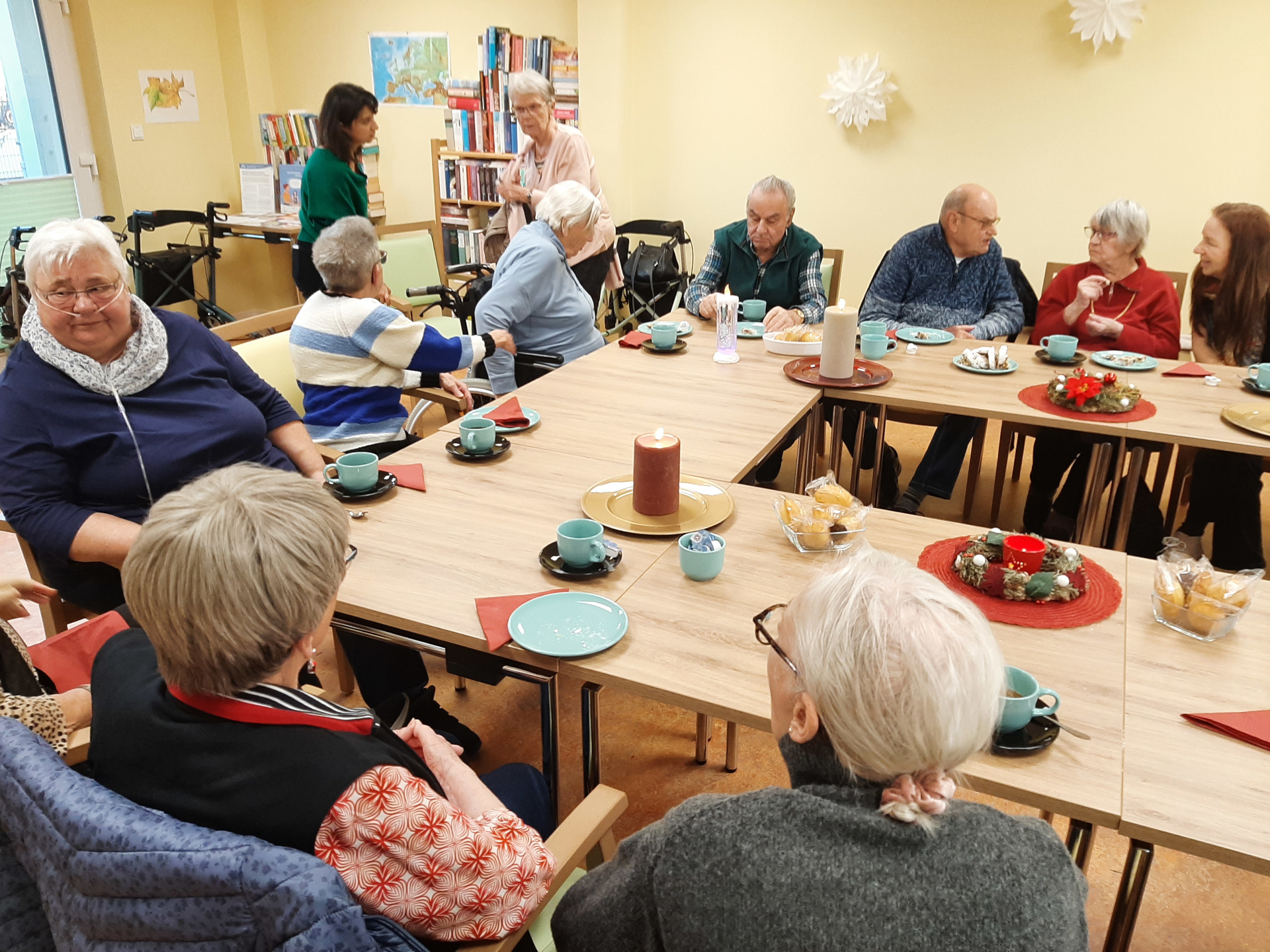 Besucher und Besucherinnen sitzen am Tisch
