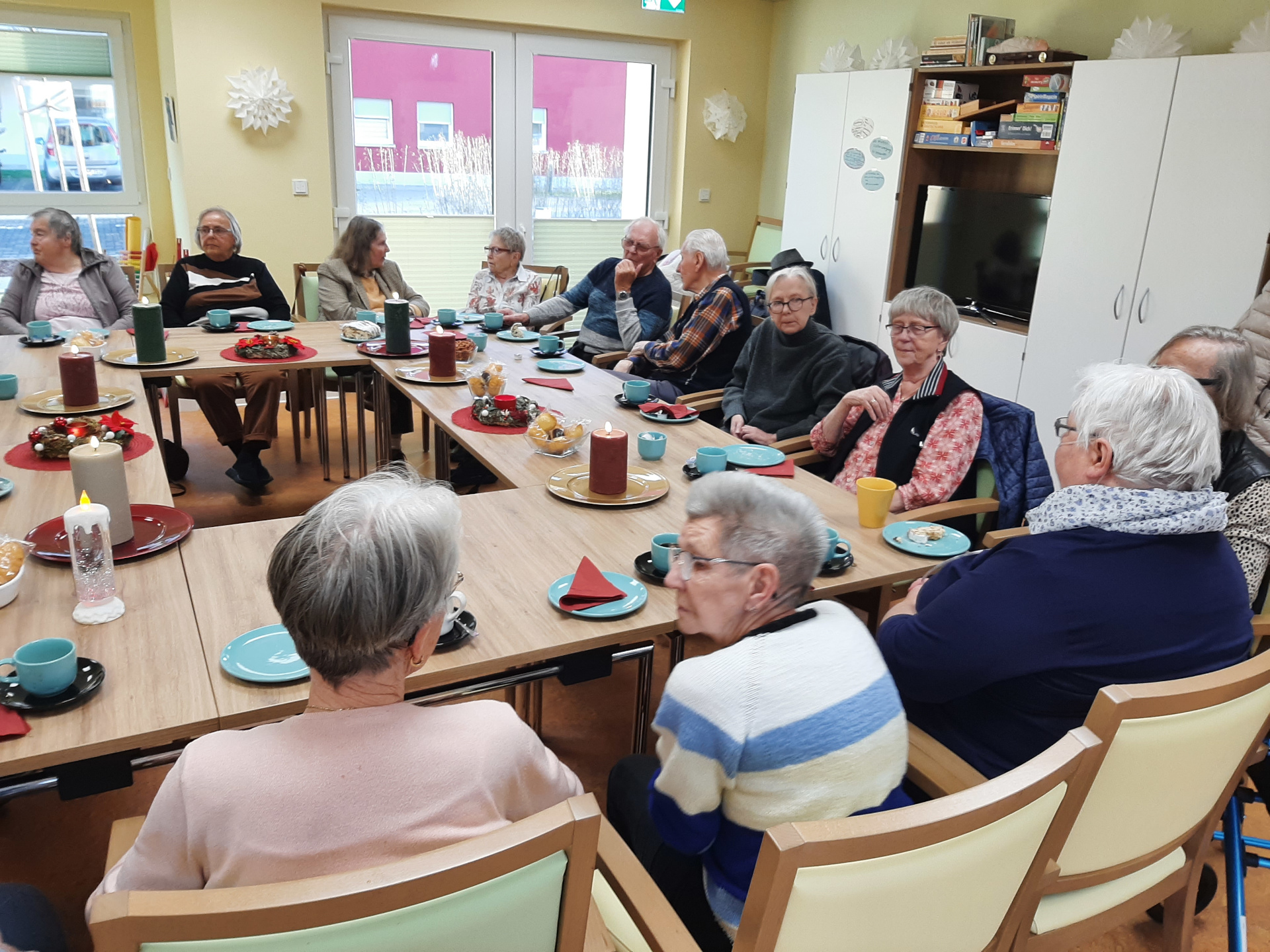 Besucher und Besucherinnen sitzen am Tisch