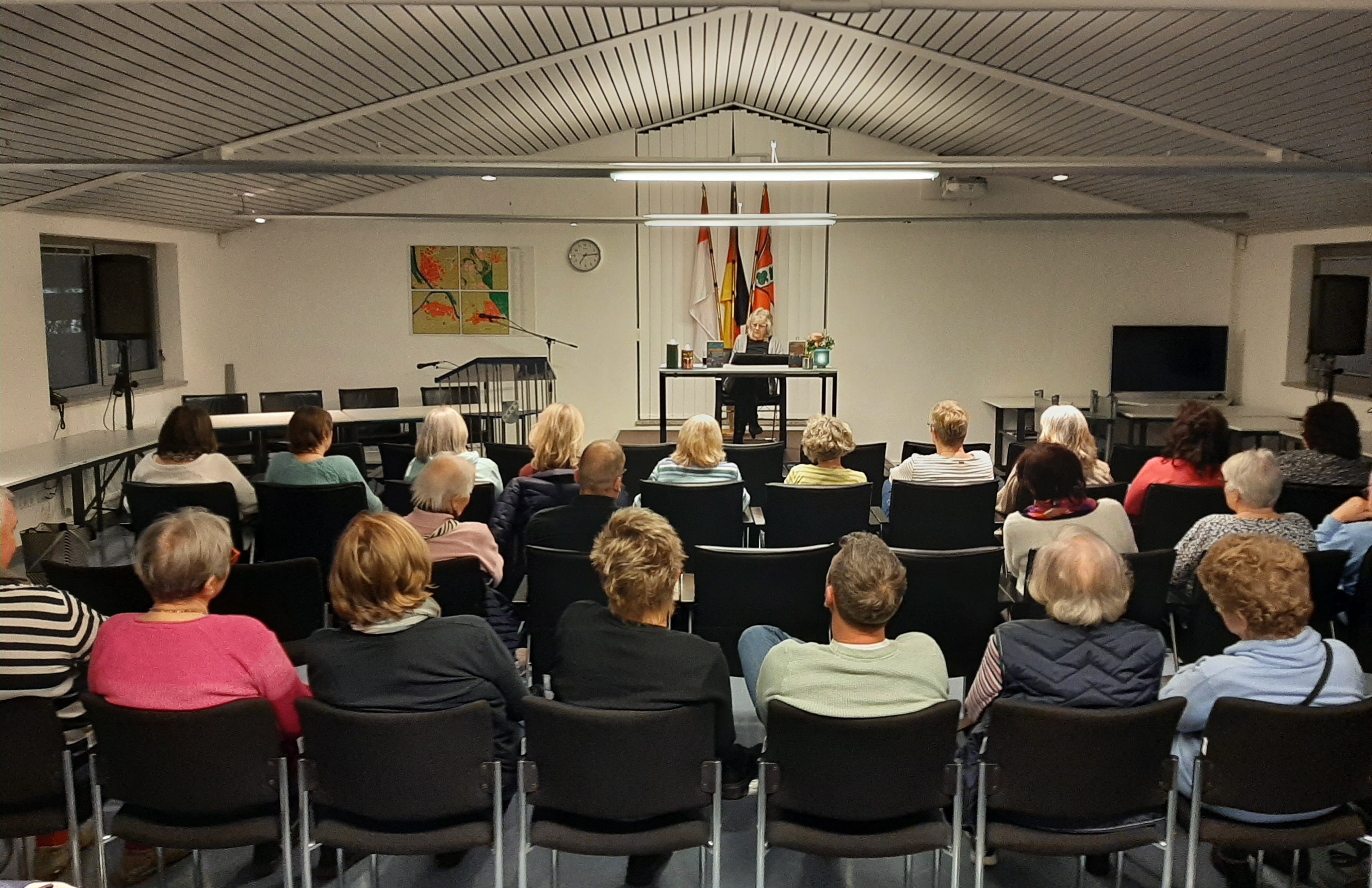 BesucherInnen sitzen im Saal und hören der Lesung zu