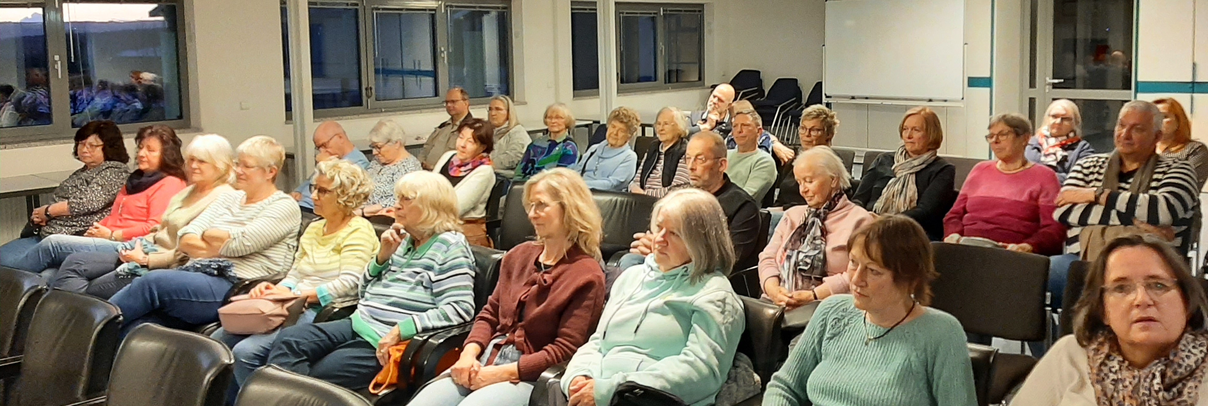 BesucherInnen sitzen im Saal und hören der Lesung zu