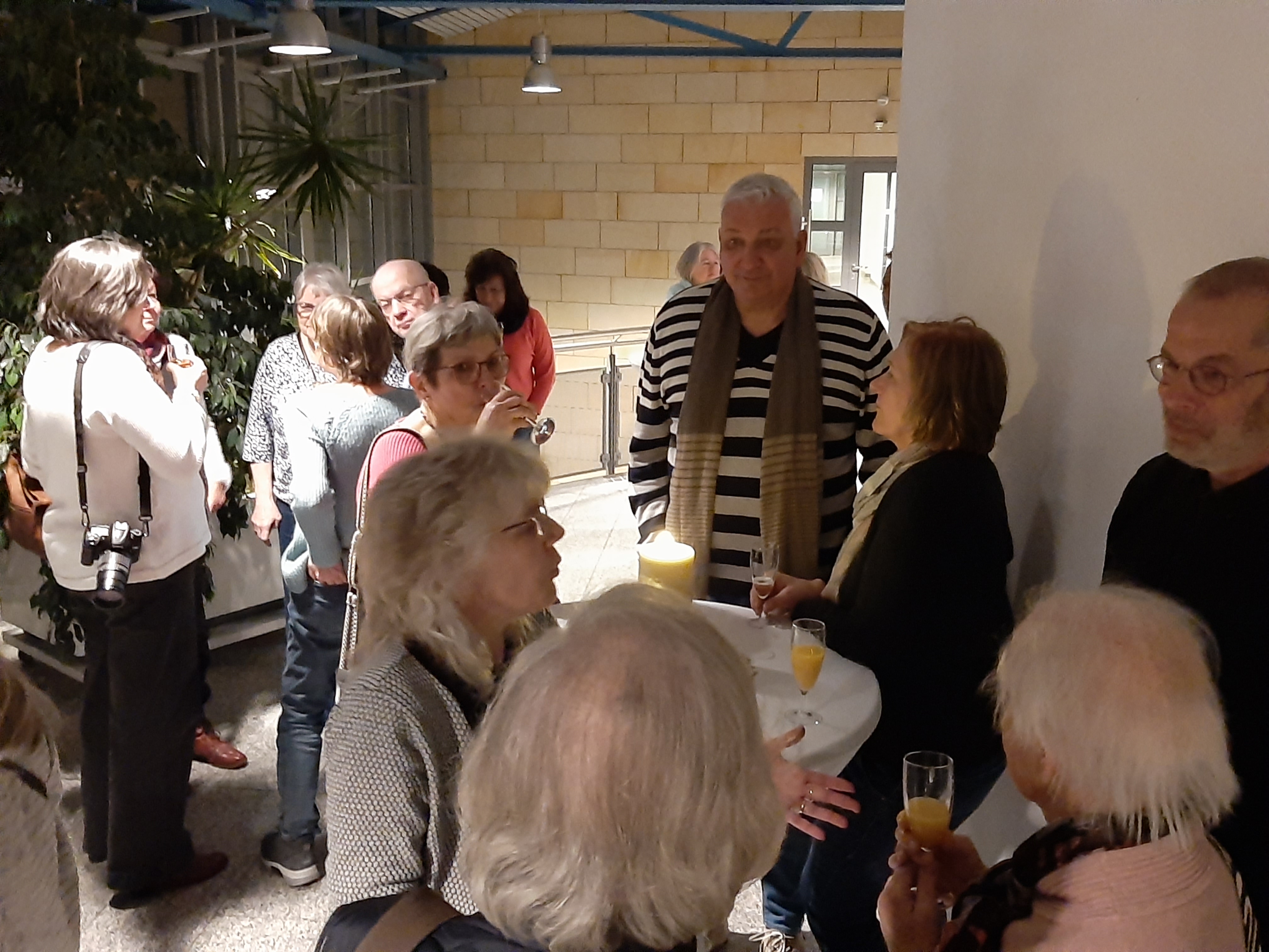 Menschen stehen im Flurbereich beim Sektempfang