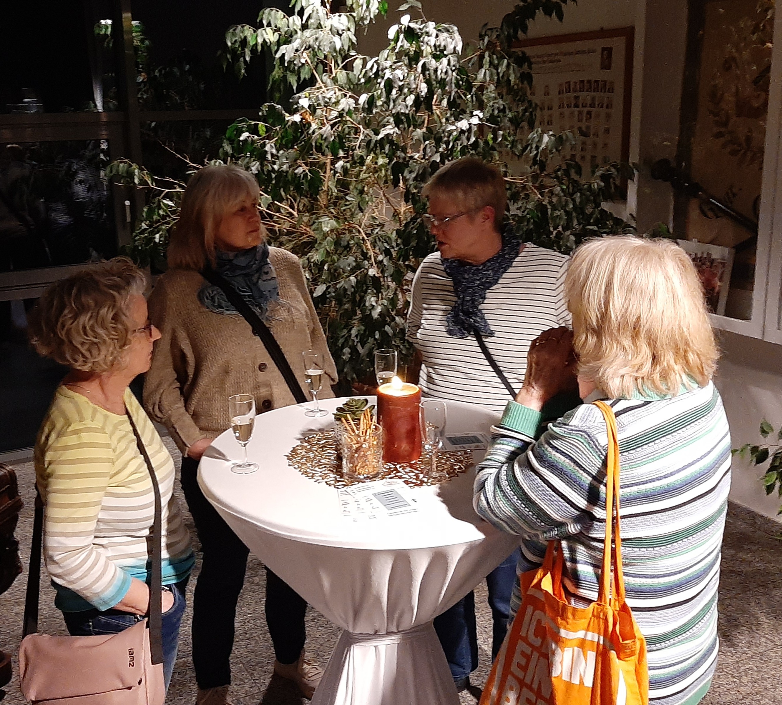Menschen stehen im Flurbereich beim Sektempfang