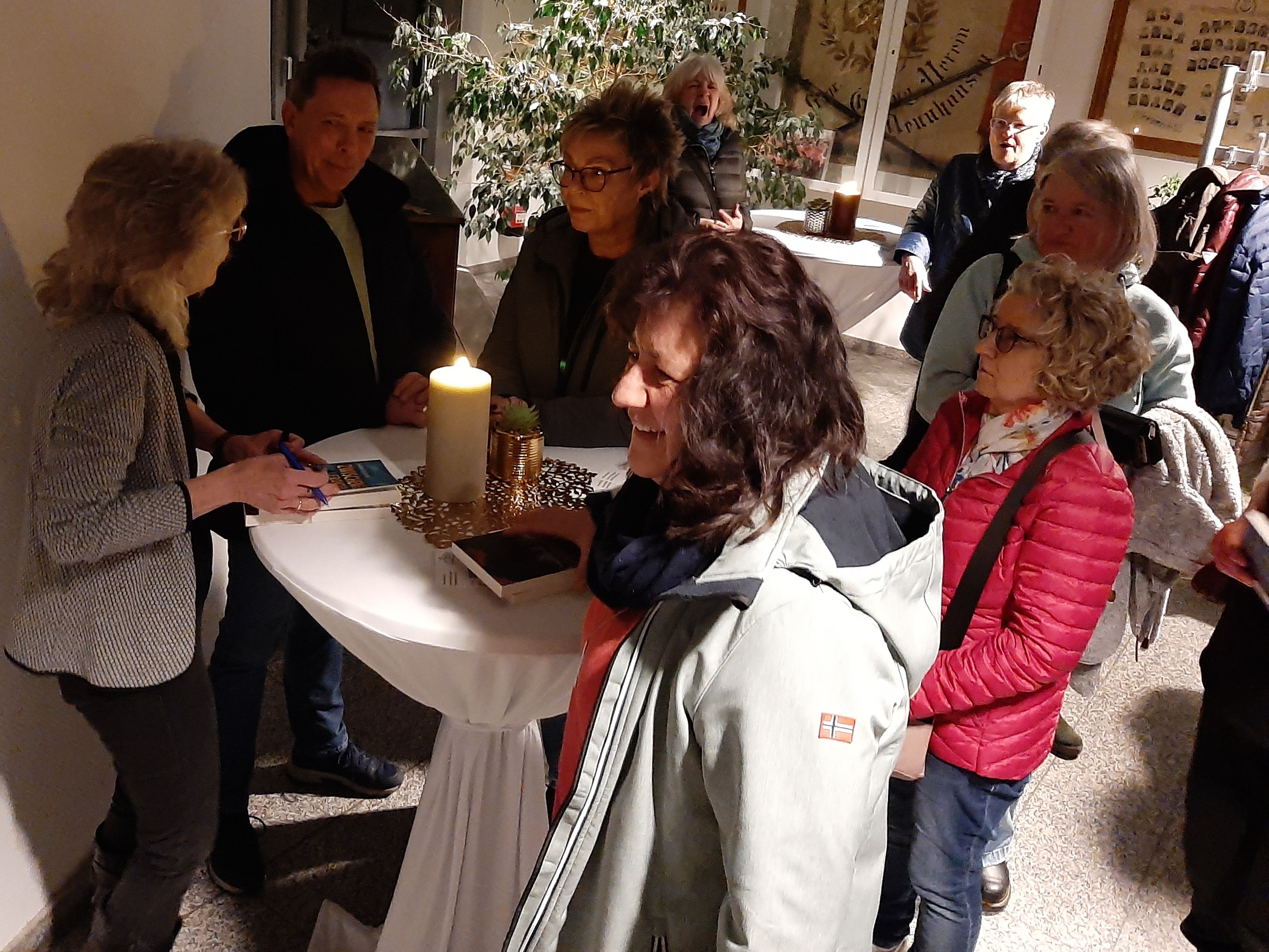 Menschen stehen im Flurbereich beim Sektempfang