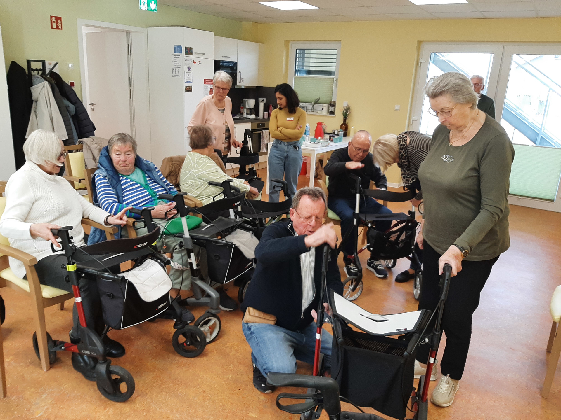 Senioren sitzen auf Stühlen und lauschen Vortrag